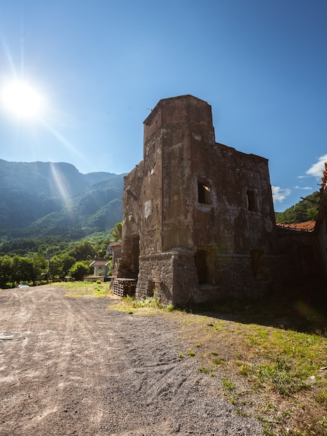 Ancient ruined tower of castle on side of the road at sunny day