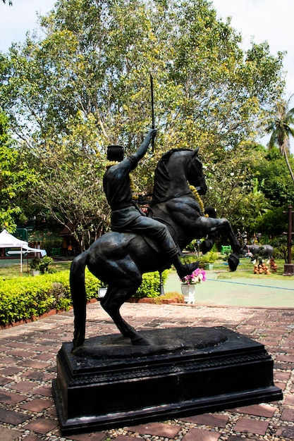 태국인과 외국인 여행자들이 태국 수판 부리(Suphan Buri Thailand)의 수판부리(Suphanburi) 시를 방문하는 왓 케(Wat Khae) 사원의 쿰 쿤 팬(Khum Khun Phaen) 정원 공원에 있는 고대 조각상이나 골동품 조각상