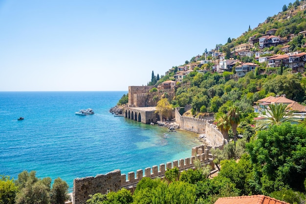 Ancient shipyard or Tersane near of Kizil Kule tower and beautiful beach and calm turquoise sea surface in Alanya Turkey