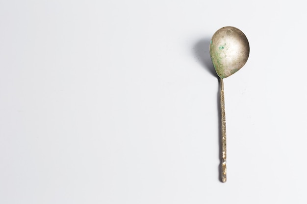 Ancient spoon on white surface.