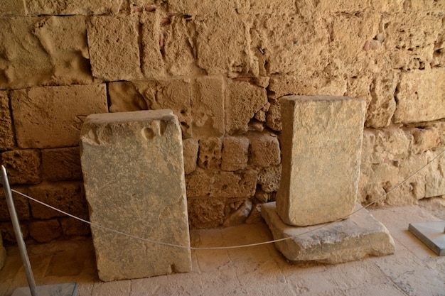 Lastre di pietra antiche isolate con muro di mattoni sullo sfondo, primo piano