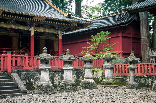 Ancient stone lanterns with Japanese temple behind