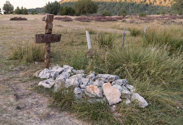 Ancient tomb with stones and wooden cross