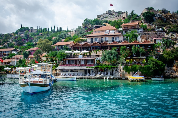 Ancient village of Simena with castle on mountain. Boat dock, beautiful landscape. 