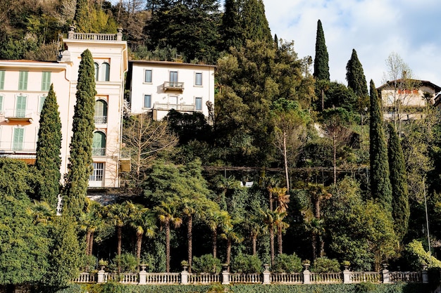 Ancient villas surrounded by trees behind a fence lake como italy