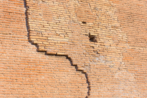 Ancient wall several layers of red brick the crack collapses