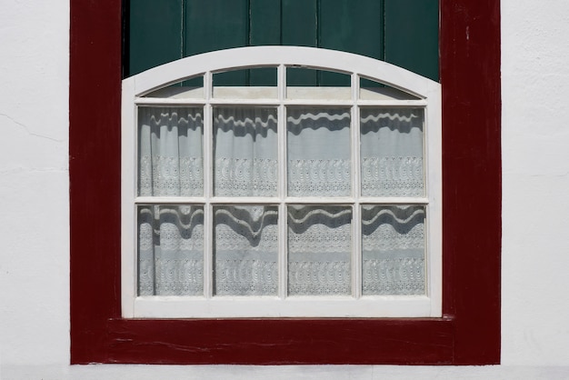 Ancient window decorated with lace curtain