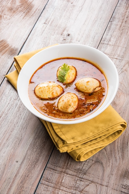 Anda Curry or Egg masala gravy, indian spicy food or recipe, served with Jeera Rice,roti or naan, selective focus. Over colourful or wooden table top