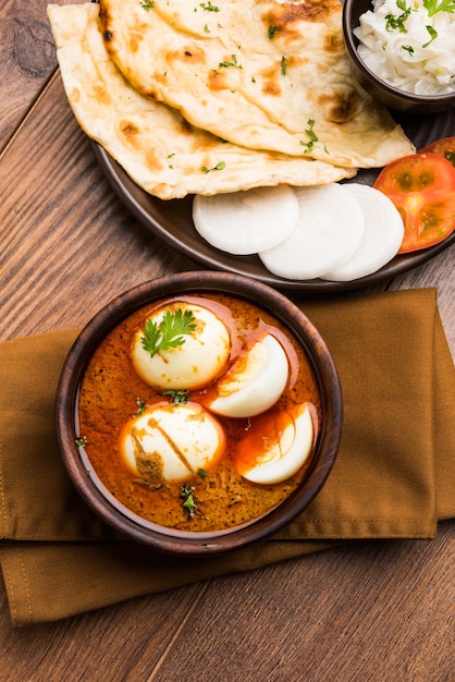 Anda Curry or Egg masala gravy, indian spicy food or recipe, served with roti or naan, selective focus