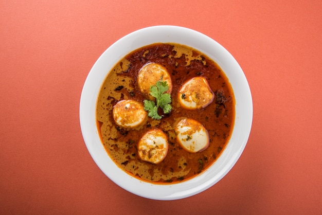 Anda Curry of Egg masala jus, Indiaas gekruid eten of recept, geserveerd met Jeera Rice, roti of naan, selectieve focus. Over kleurrijk of houten tafelblad