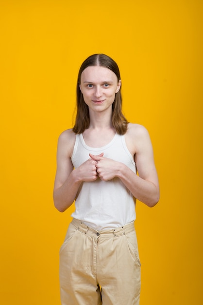 Androgyne jonge man in mannen outfit binnenshuis. Studio opname