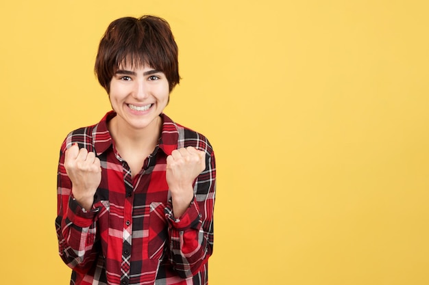 Androgyne persoon viert feest terwijl hij de vuisten opheft