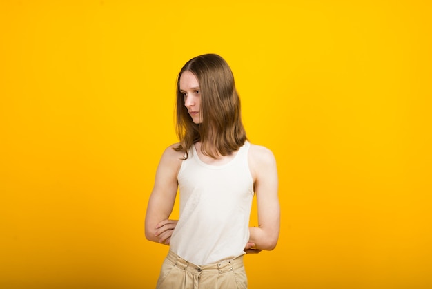 Androgynous beautiful young man. model tests in yellow background