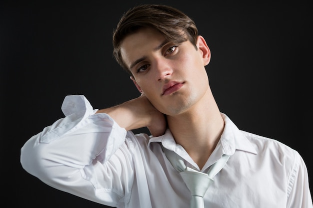 Androgynous man posing with hands on his head