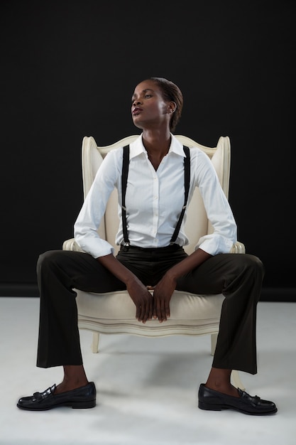 Androgynous man sitting on a chair