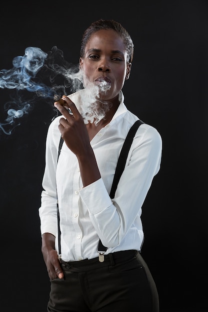 Androgynous man smoking a cigar