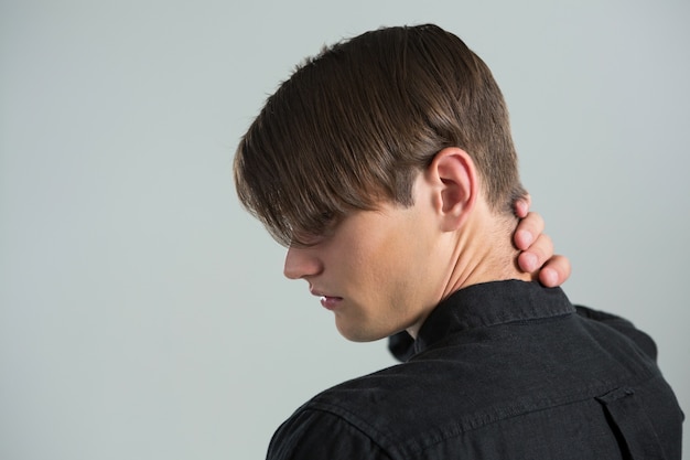 Androgynous man touching his neck