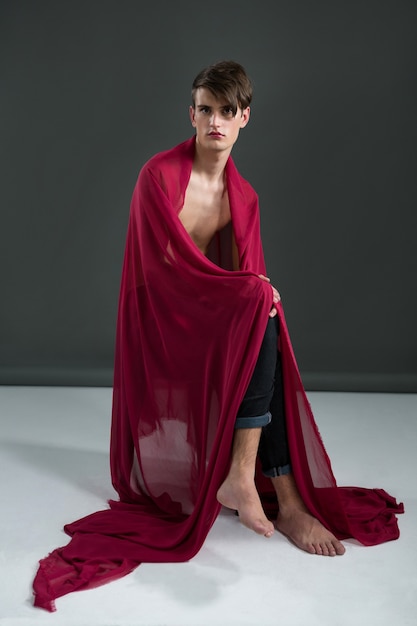 Androgynous man wrapped in red clothes