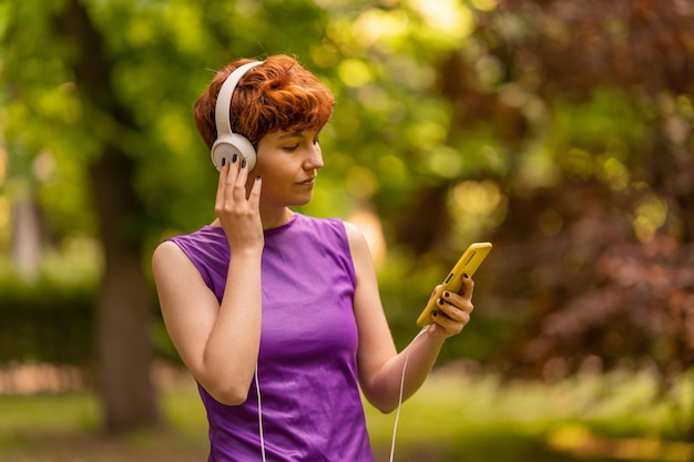 Androgynous woman using smartphone and listening to music