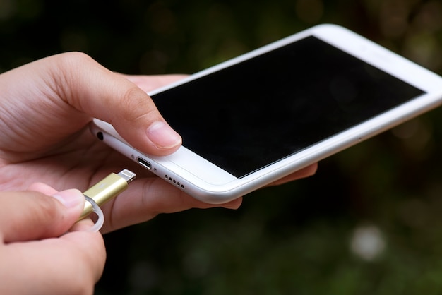 Foto ands een lader aansluiten op een smartphone op buiten