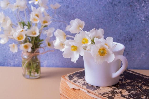 Anemonen bloemboeket in een kopje en vinage boek Lente Moederdag of 8 maart stilleven compositie