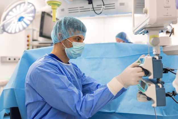 Anesthesiologist keeping track of vital functions of the body during cardiac surgery Surgeon looking at medical monitor during surgery Doctor checking monitor for patient health status