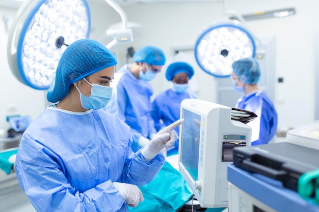 Anesthesiologist keeping track of vital functions of the body
during cardiac surgery surgeon looking at medical monitor during
surgery doctor checking monitor for patient health status