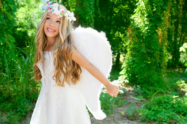 Angel children girl open arms in forest white wings