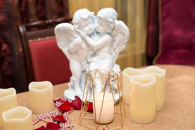 Foto figure d'angelo, candele e petali di rosa, cena romantica in un ristorante