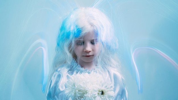 Angel girl. Child art portrait. Heaven blessing. Ethereal aura. Sweet blonde little kid with white flowers in blur iridescent fluorescent glow strokes on blue copy space background.