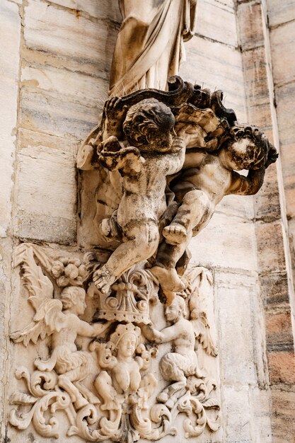 Angels hold a pedestal on the facade of the duomo milan italy
