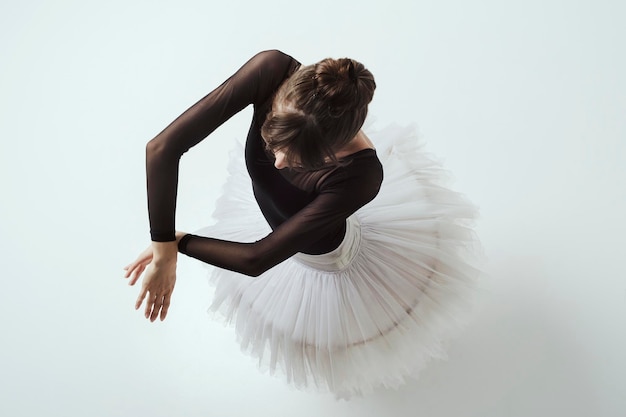 Photo an angle from above on a ballerina up to the waist with her hands showing a dance