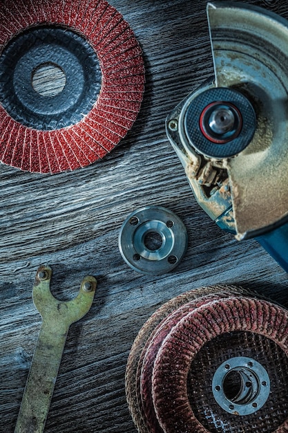 Angle grinder sanding discs key on vintage wooden board.