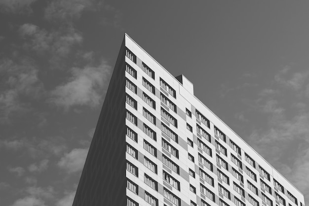 Angle of the Skyscraper on the Cloudy Sky Background. Black and White.