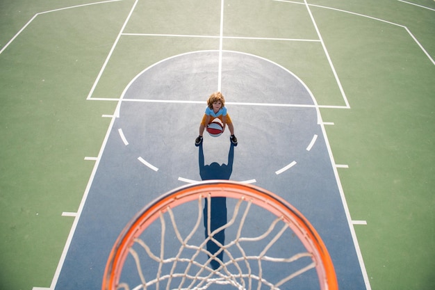 Angle view from on top of child playing basketball on playground