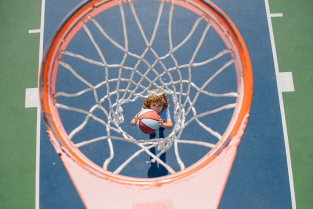 Angle view from on top of child playing basketball on playground