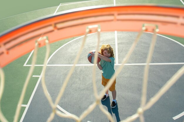 Angle view from on top of flying ball to basket from kid play basketball