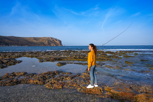 Ragazza di pesca del pescatore in spiaggia mediterranea di javea