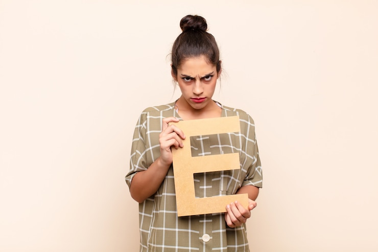 फोटो angry, anger, disagreement, holding the letter e of the alphabet to form a word or a sentence.