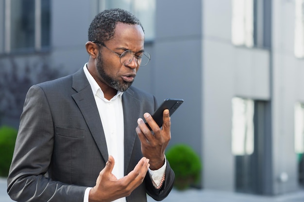 Angry and angry boss talking and shouting on mobile phone african american businessman in business