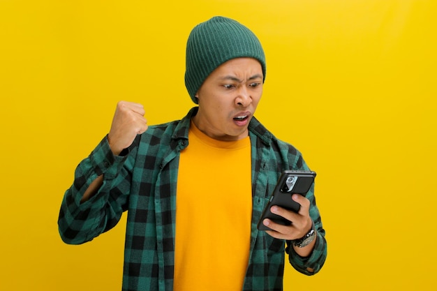 怒ったアジア人男性は携帯電話を見ながら明らかに悪いニュースに反応します