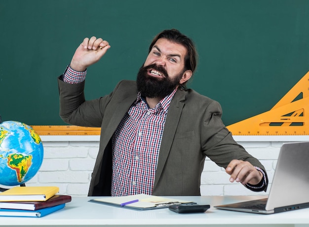 Insegnante o studente barbuto arrabbiato prova rabbia per i cattivi risultati dell'istruzione scolastica, le emozioni.