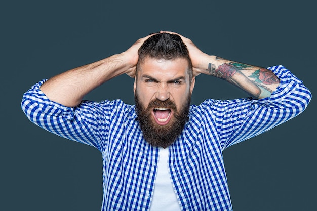 Angry bearded man wear checkered shirt on grey background