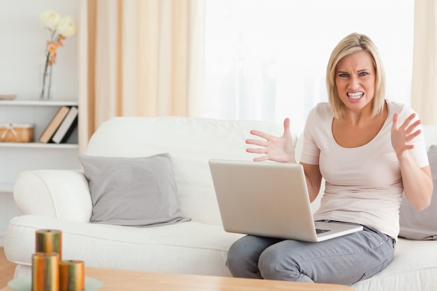 Foto donna bionda arrabbiata utilizzando un computer portatile