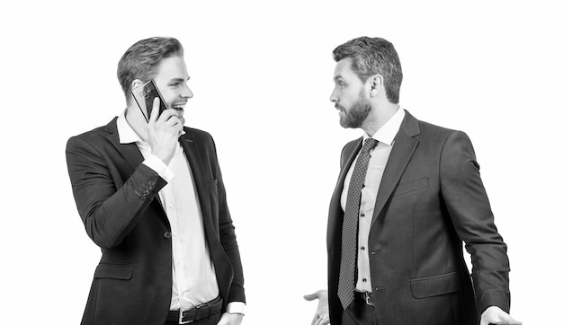 Angry boss arguing with smiling employee speaking on phone isolated on white conflict