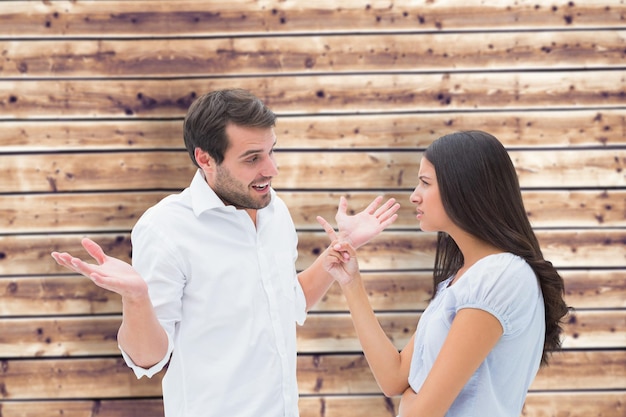 Angry brunette accusing her boyfriend against wooden planks background