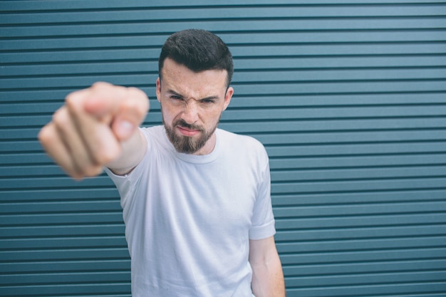 Angry and brutal man is looking and pointing on camera