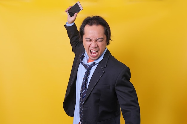 Angry businessman experienced stressed business man feeling\
very angry while throwing his smartphon