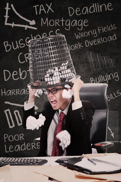 Photo angry businessman hold rubbish bin in class