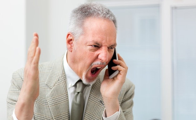 Angry businessman shouting on the phone